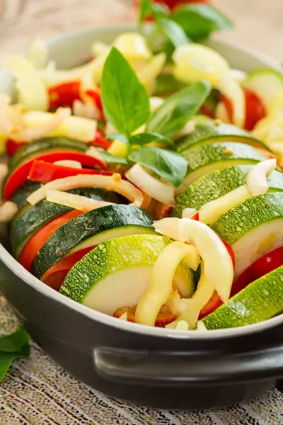 stock image raw zucchini and tomatoes sliced and prepared for baking in a ceramic dish, vegetable appetizer .