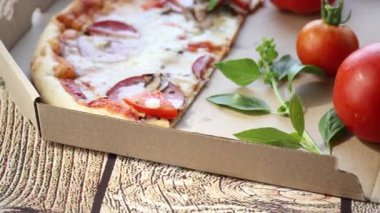 Salamlı pizza ve sosis ahşap bir masada bir kutuda. .