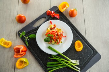 Bezelye, sosis ve tatlı biberli haşlanmış sebze salatası. Tahta bir masada. .