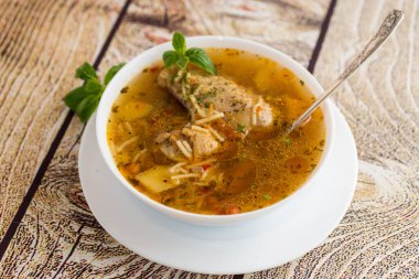 Ahşap bir masada sıcak tavuk ve erişte çorbası..