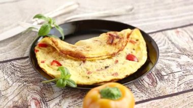 Tahta masadaki tabakta tatlı biber ve sebzeli omlet..