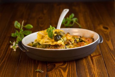 Karnabahar ve Brüksel lahanası, ahşap bir masada seramik tabakta peynirli güveç. .