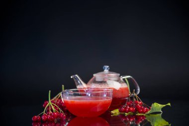 Siyah arka planda izole edilmiş viburnum böğürtlenlerinden besleyici vitamin çayı .