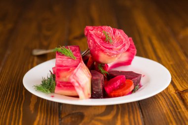 Pancar ve havuçlu lahana turşusu, bir tabakta, ahşap bir masada. .