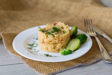 Ev yapımı bulgur, ahşap bir masanın üzerinde, bir tabakta Brüksel lahanası. .