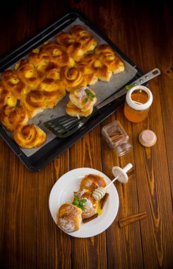 Hamur işleri. Süzme peynirli tatlı çörekler ve ahşap bir masada bir tabakta bal .