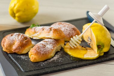 Hamur işleri. Ayva ve ballı çörekler, ahşap bir masada .