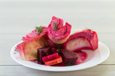 Pancar ve havuçlu lahana turşusu, bir tabakta, ahşap bir masada. .