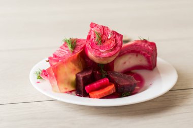 Pancar ve havuçlu lahana turşusu, bir tabakta, ahşap bir masada. .