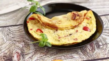 Tahta masadaki tabakta tatlı biber ve sebzeli omlet..