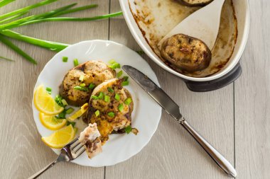 Tahta bir masada, limonlu ve otlu ev yapımı balık tabağı..