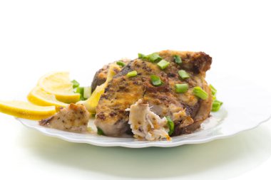 Tabakta yeşil otlar ve limonlu balık, beyaz arka planda izole edilmiş..