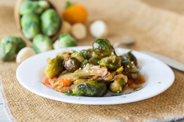 Ahşap bir masada sebze ve baharatla pişirilmiş Brüksel lahanası. .