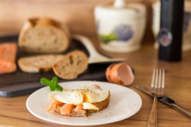 Hafif tuzlu kırmızı balıklı bir dilim ekmek ve kahvaltıda pişmiş yumurta..