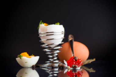 Kahvaltı için kırmızı havyar ve haşlanmış yumurta, siyah arka planda izole edilmiş..