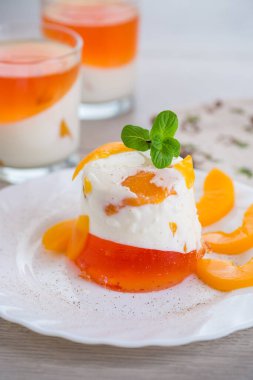 Yoğurt kremalı ve ahşap bir masada meyveli bir bardakta reçelli tatlı..