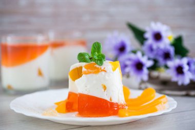 Yoğurt kremalı ve ahşap bir masada meyveli bir bardakta reçelli tatlı..