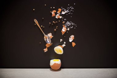 Baharatlı haşlanmış yumurta ve siyah arka planda kabuk..