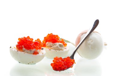 Beyaz arka planda kırmızı havyarlı haşlanmış yumurta..