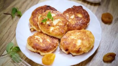 Kurutulmuş kayısılı süzme peynir krepleri ve ahşap bir masada bal..