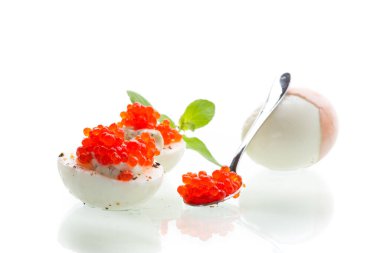 Beyaz arka planda kırmızı havyarlı haşlanmış yumurta..