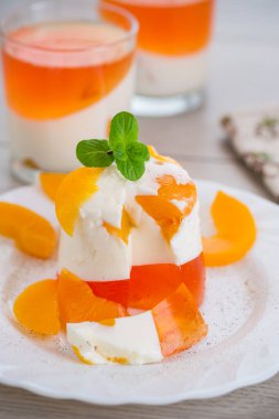 Ahşap bir masada reçelli, kremalı ve taze naneli meyve tatlısı..