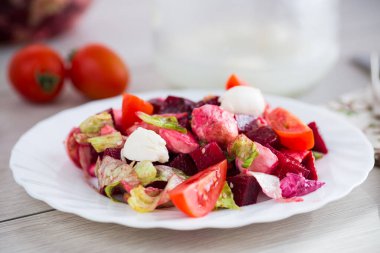 Mozarella soslu diyet salatası ve açık ahşap bir masada pancar kökü..