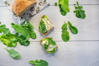 Ringa balığı ve salata yapraklı bir sandviçin yakın çekimi..