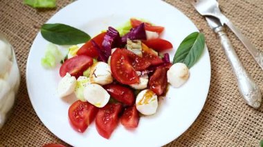 Mozzarella soslu salata ve ahşap bir masada domates..