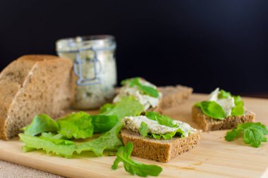 Roka, salata ve yumuşak peynirli sağlıklı bir sandviç..