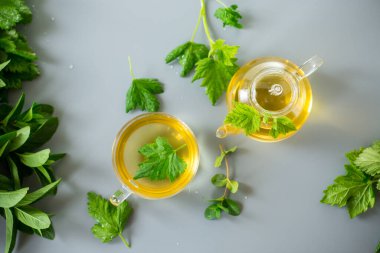 Frenk üzümü yapraklarından yeşil çay ve cam bir kapta nane..