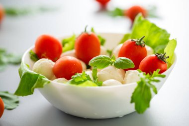 Mozzarella, kiraz domatesleri ve yeşilliklerle nefis bir kompozisyon..