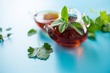 Cam bardak ve çaydanlıkta taze bitkisel karışım..