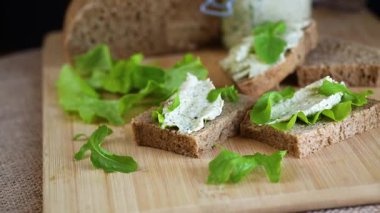 Roka, salata ve yumuşak peynirli sağlıklı bir sandviç..