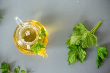 Nane ve üzümlü yapraklardan çaydanlık ve fincanda Aromatik içecek.