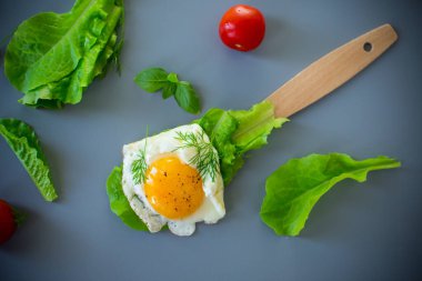 Mutfakta salata yapraklı, gri arka planda lezzetli yumurta yakın plan..