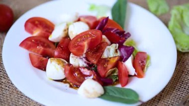 Mozzarella, domates ve yeşil yapraklı aperatif..