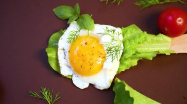 Tahta spatula ve kahverengi arka planda sebzeli sahanda yumurta..