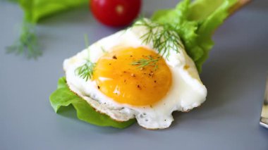 Gri arka planda ahşap spatulada yeşil yumurta..