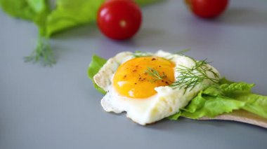 Gri arka planda ahşap spatulada yeşil yumurta..