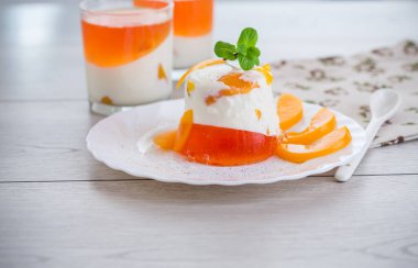 Yoğurt kremalı ve ahşap bir masada meyveli bir bardakta reçelli tatlı..