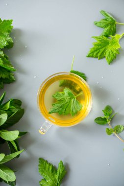 Frenk üzümü yapraklarından yeşil çay ve cam bir kapta nane..