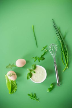 Yeşil arka planda otlu ve yumurtalı ev yapımı mayonez..