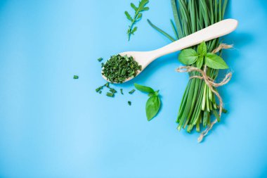 Mavi arka plandaki ev mutfağında kışa kurutulmuş soğan hazırlanıyor..