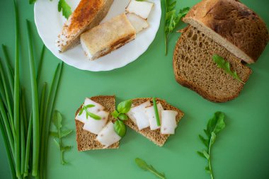 Yeşil zemin üzerinde domuz yağı ve yeşillik bulunan geleneksel Ukrayna yemeği.