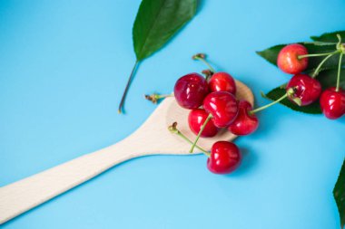 Yukarıdan mavi arkaplanda olgun kırmızı kirazlar.