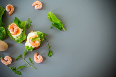 Yukarıdan karides, yumurta ve yeşilliklerle iştah açıcı kahvaltı.