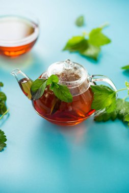 Frenk üzümünden yeşil çay ve cam çaydanlıkta nane yaprakları..