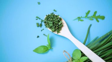 Kurumuş bitkilerin ve mavi arka planda taze yeşil soğanların üst görüntüsü