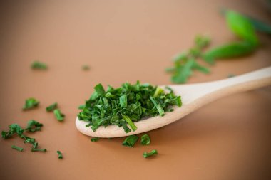 Kahverengi yüzeyde taze ve kurutulmuş soğan dilimleri.